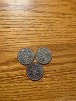 Three coins reverse side showing Canadian Coat of Arms
