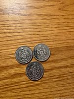 Reverse sides of three 1971 Canadian 50-cent coins showing Canadian Coat of Arms