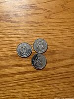 Three 1973 Canadian 50-cent coins reverse side with Coat of Arms