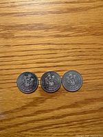 Three coins reverse side showing Canadian coat of arms