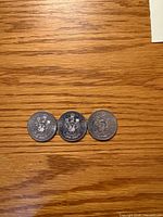 Three 1986 Canadian 50-cent coins reverse side showing Coat of Arms