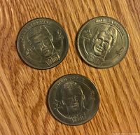 Three McDonald’s brass-tone NHL coins featuring Steve Yzerman, Rob Zamuner, Adam Foote on wood surface