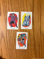 Fronts of three Batman cards showing illustrations and titles