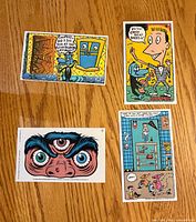 Fronts of four Pee-wee’s Playhouse trading cards laid out on wood surface
