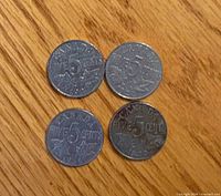 Reverse of four Canadian 5-cent coins showing denomination and maple leaves