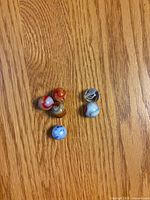 Six coloured glass marbles grouped on wood surface