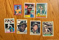 Front view of seven Rickey Henderson baseball cards laid out on wood surface
