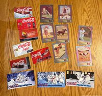 All items laid out on hardwood floor: 10 grey-border sports trading cards at center/right, 4 Polar Bears phone cards bottom, 4 assorted Classic/Light phone cards left/top