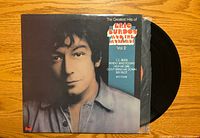 Front sleeve portrait and partial view of black vinyl record