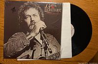 Front cover, partial view of black vinyl record and white inner sleeve