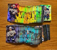 Stacks of Tim Hortons Upper Deck NHL hockey cards spread on a wooden surface showcasing foil designs