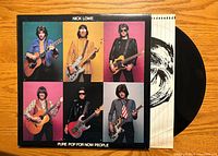 Front of Nick Lowe Pure Pop for Now People LP with black vinyl partly removed from inner sleeve