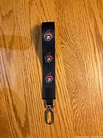 Full view of black Ottawa Senators wrist lanyard showing logos and metal swivel clip