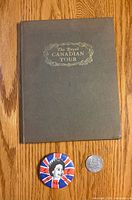 Front cover of hardcover book with button and medallion for scale