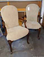 Front view of both mahogany armchairs with tan upholstery
