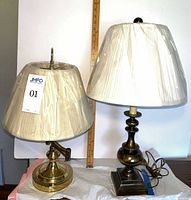 Both brass desk lamps with shades displayed side by side