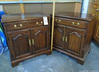 Front view of both matching mahogany nightstand cabinets showing drawer, doors, brass hardware