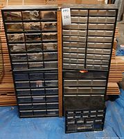 Front view of two tall plastic drawer cabinets and one smaller unit showing overall lot