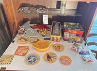 Overall lot on shelf showing ashtrays, coasters, bar accessories, guide book and glasses