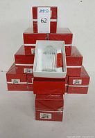 Stack of eleven red Baccarat boxes with one opened showing glass and packaging