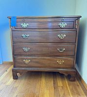 Front view of Kittinger Williamsburg 4-drawer chest showing brass pulls and bracket feet