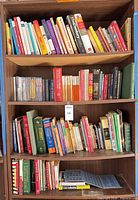 Full view of three shelves showing mixed books, DVDs, and penny folder