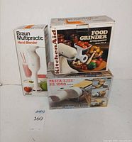 Three boxed products: Braun Hand Blender, KitchenAid Food Grinder, Pasta-Ezee PE 1000