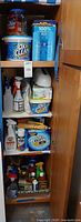 Full cabinet view showing multiple shelves of cleaning products