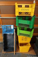 Stack of specialty recycling crates and blue crate against wall