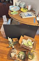 Overall lot showing tableware on curved table, cabbage plates in box, large rabbit figurine and additional rabbit figurine