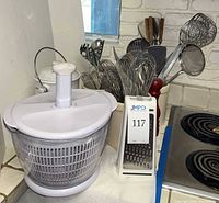 salad spinner, box grater, portion of utensil crocks
