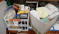 Crate with microfiber towels, applicator pads, blast off can, adjacent box with assorted towels