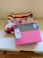 Quilt folded next to sealed sheet set on table