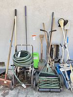 group shot of hose reel, hose, push mower, kneeler, broom and long-handled tools