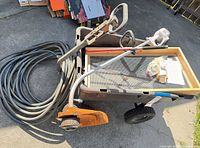 Overall lot showing wagon, trimmer, hose, and sifter