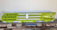 Three boxed 4 ft LED shoplights and boxed two-pack of 4 ft LED tubes