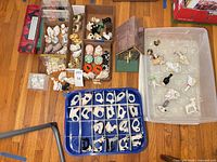 Overview of napkin rings in blue tray, salt & pepper shakers in boxes, and birdhouse