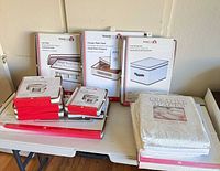 Sealed Household Essentials boxes for cup chest, charger plate chest, large storage bin plus stacked smaller chests