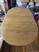 top view of oval wooden dining table with leaves inserted
