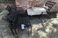 Group shot of chaise lounge with cushions and four metal slat chairs