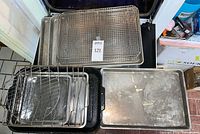 Stacked baking sheets and racks in oven opening