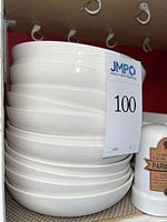 Stack of white shallow bowls on shelf