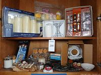 Overview of full cabinet showing boxed LED candles, novelty candles, taper candles, glass holders, candle warmer