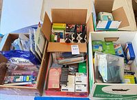 Overview of three boxes showing majority of unopened toiletries, soaps, wipes, razors and first-aid items