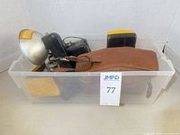 Plastic bin containing cameras, cases, film tins