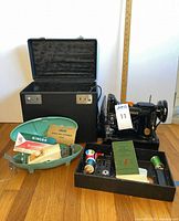 Overall lot showing sewing machine, open case, buttonholer cases and accessories