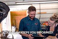 Technician and customer viewing tablet in garage