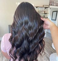 Back view of styled long dark brown wavy hair, example of salon work
