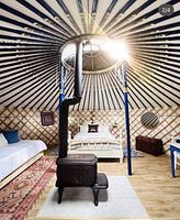 Interior of Mongolian yurt with queen bed, wood stove and skylight