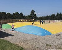 Large outdoor inflatable jumping pillow with visitors, representative of Playland attractions